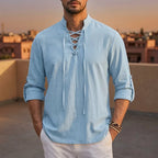 Close-up of a light blue lace-up shirt showing the crisscross cord detail at the neckline