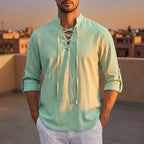 Sage green lace-up shirt with mandarin collar worn with the sleeves rolled and buttoned