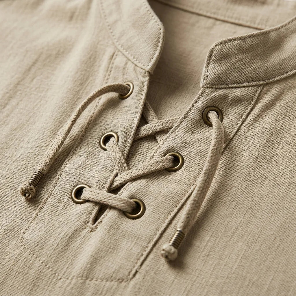 Close-up of the bronze eyelets and woven lace-up cords on a beige cotton-linen shirt collar
