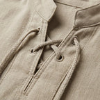 Detailed close-up of the crisscross lacing, eyelets and collar stitching on a beige shirt