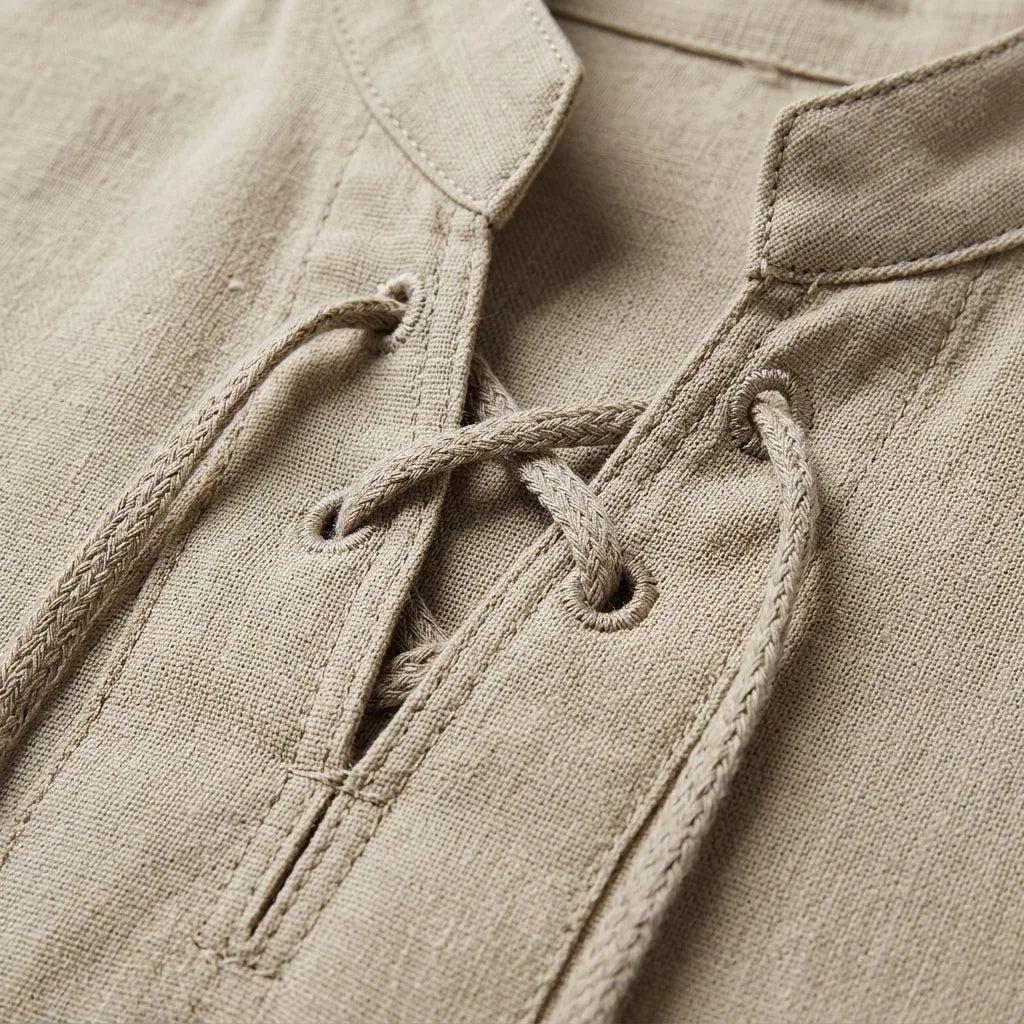 Detailed close-up of the crisscross lacing, eyelets and collar stitching on a beige shirt