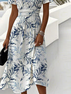 Side view of the flowing midi skirt showing the botanical leaf print and soft fabric drape at the hemline.
