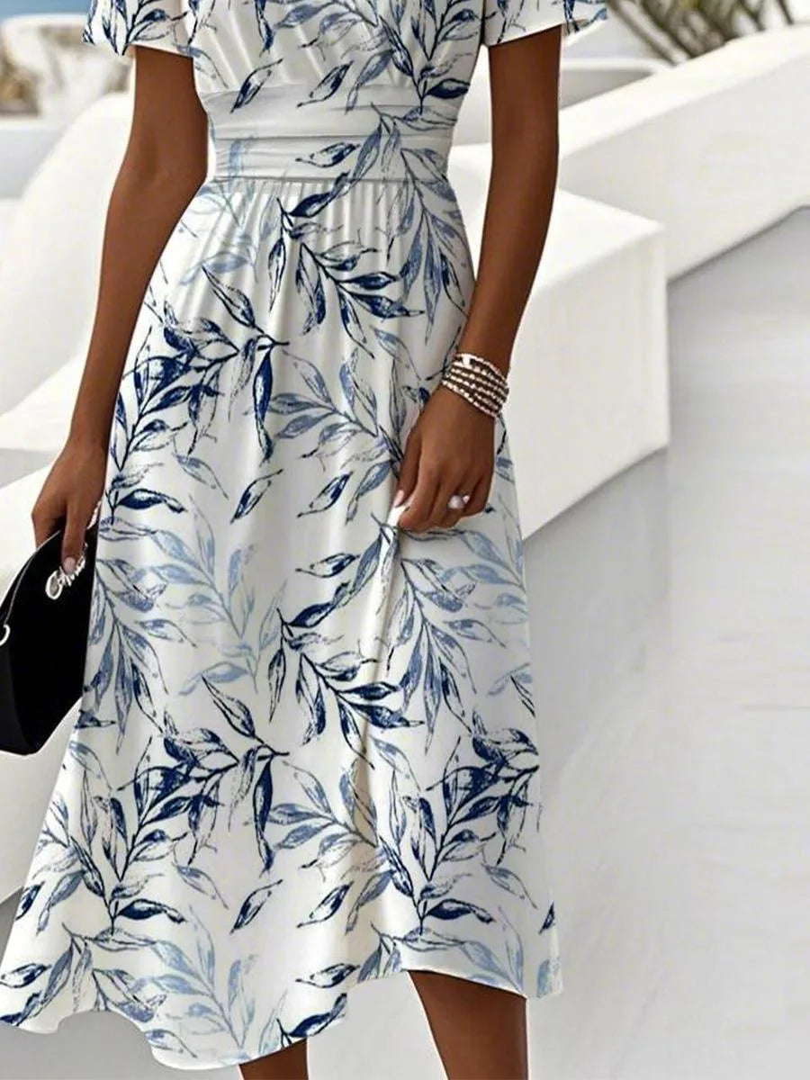 Side view of the flowing midi skirt showing the botanical leaf print and soft fabric drape at the hemline.