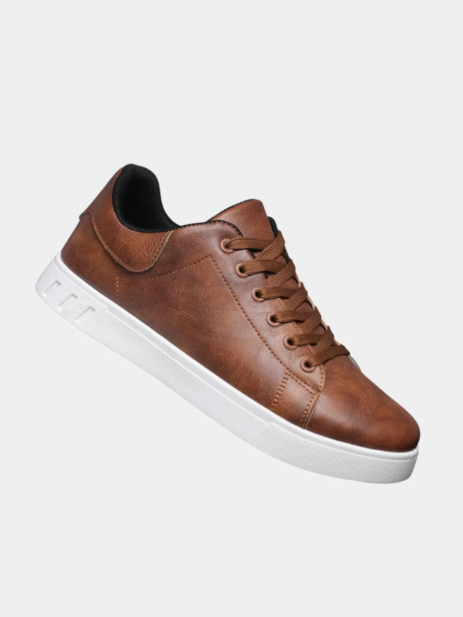 Angled side view of brown leather sneaker showing lace-up front, black heel lining and white ridged outsole