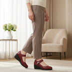 Side view of a woman walking in burgundy leather Mary Jane wedge shoes with an adjustable ankle strap