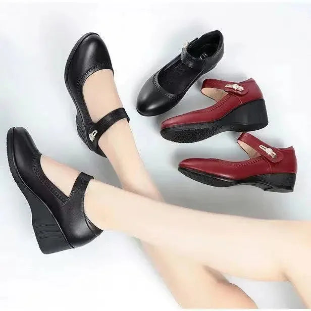 Close-up of burgundy leather Mary Jane wedge shoes from the side showing the wedge heel profile and sole grip