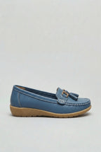 Side profile of a dusty blue leather loafer with gold-tone tassel trim and stitched moc-toe detailing