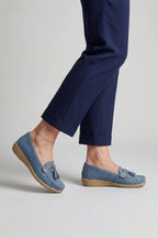 Woman wearing dusty blue leather loafers with navy tailored trousers cuffed at the ankle, street styled shot