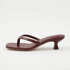 Off-white cream leather thong sandal with twin straps and a low curved heel, side view