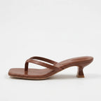 Deep red wine leather thong sandal with a square toe and sculpted kitten heel, shown in profile