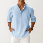 Cropped front view of a man wearing the shirt in light blue, paired with white pants and a wristwatch.