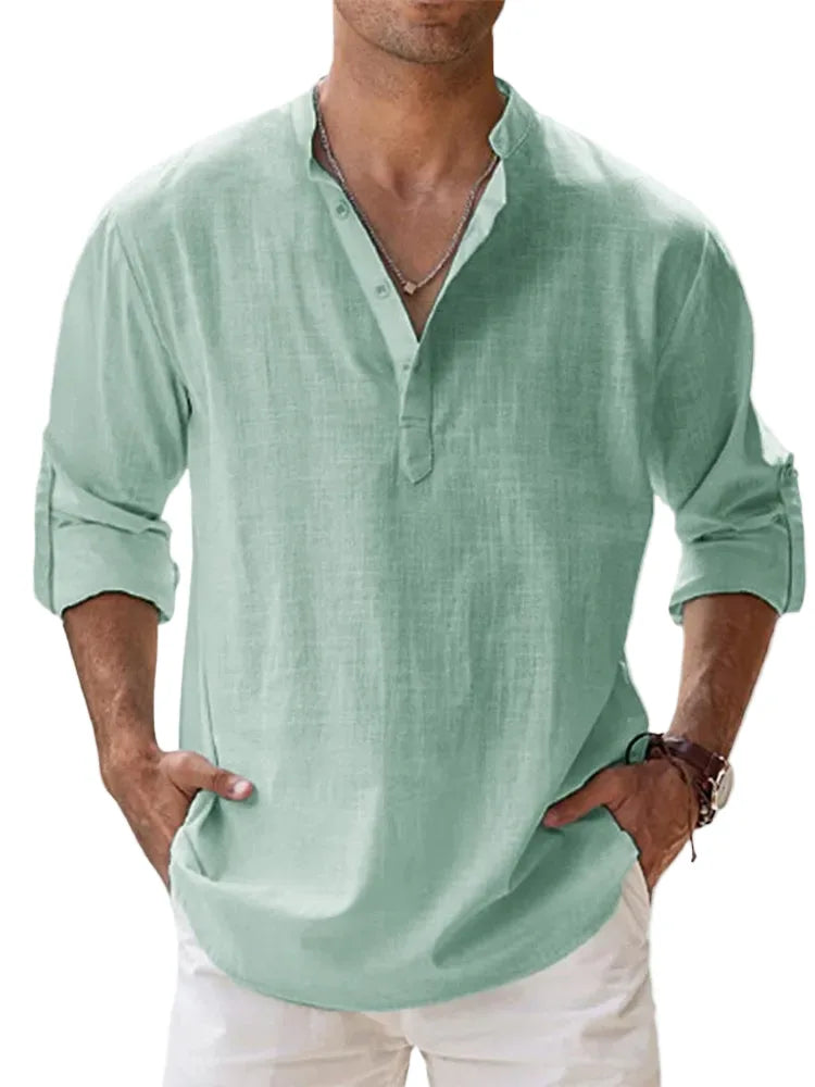 Cropped front view of a man wearing the shirt in sage green, showing the relaxed drape and rolled-up sleeves.