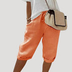 Orange linen bermuda shorts showing fabric texture and drawstring tie at the elastic waist