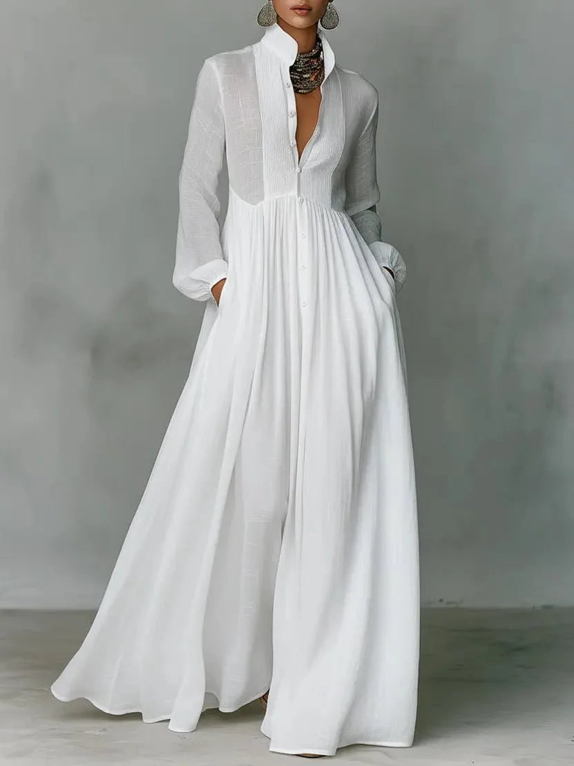 Front view of a white long-sleeve maxi shirt dress with stand collar, button placket and flowing wide skirt
