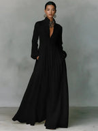 Black long-sleeve maxi shirt dress with stand collar, button-front bodice and hand tucked into side pocket
