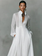 Close-up front view of the white dress highlighting the pintucked bib, pearl buttons and stand collar detail