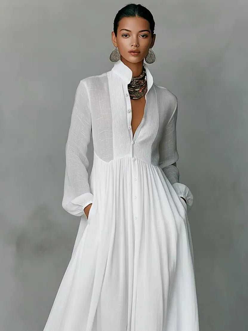 Close-up front view of the white dress highlighting the pintucked bib, pearl buttons and stand collar detail