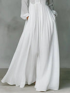Close-up of the gathered waist and flowing skirt panel showing the fabric texture and hidden side pocket