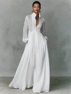 Three-quarter view of the white maxi shirt dress showing the sheer sleeves, button placket and pleated skirt fall