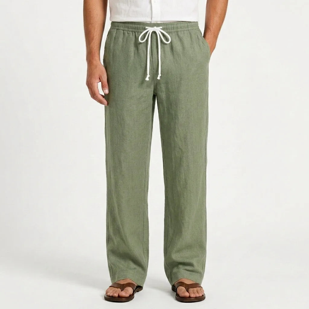 Front view of man wearing green heathered linen drawstring trousers with white shirt and brown sandals