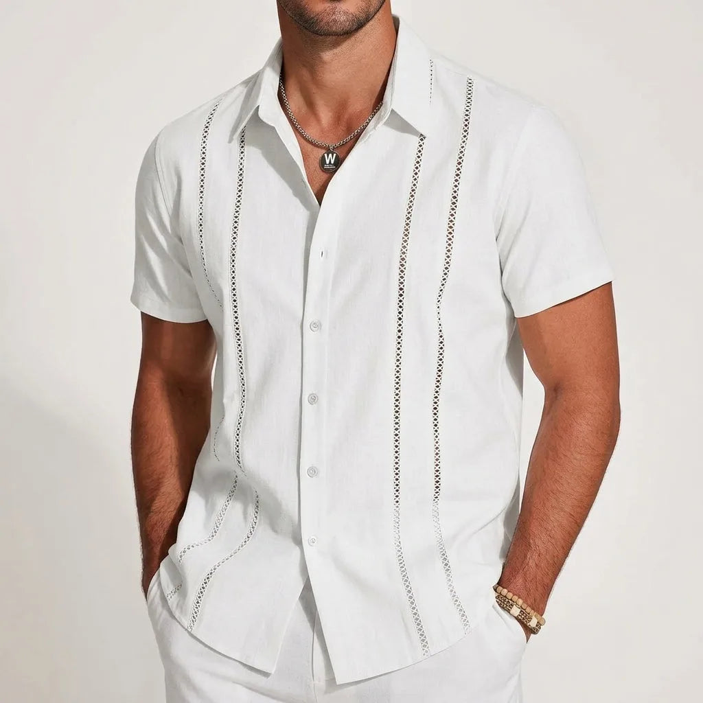 White linen-blend guayabera shirt with crochet stripe panels, paired with white trousers, front view close-up