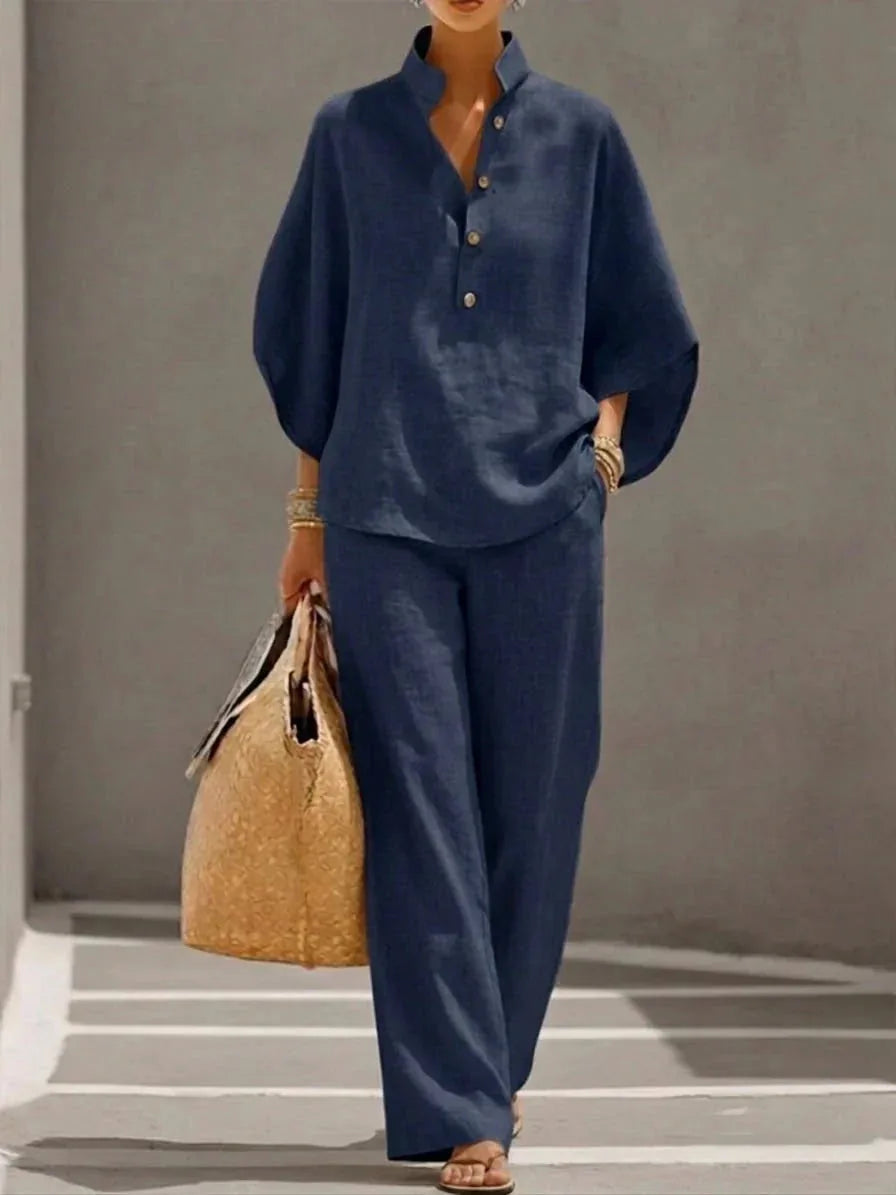 Model wears a navy blue linen-look relaxed set with batwing sleeves, mandarin collar and button placket, paired with wide-leg pants.