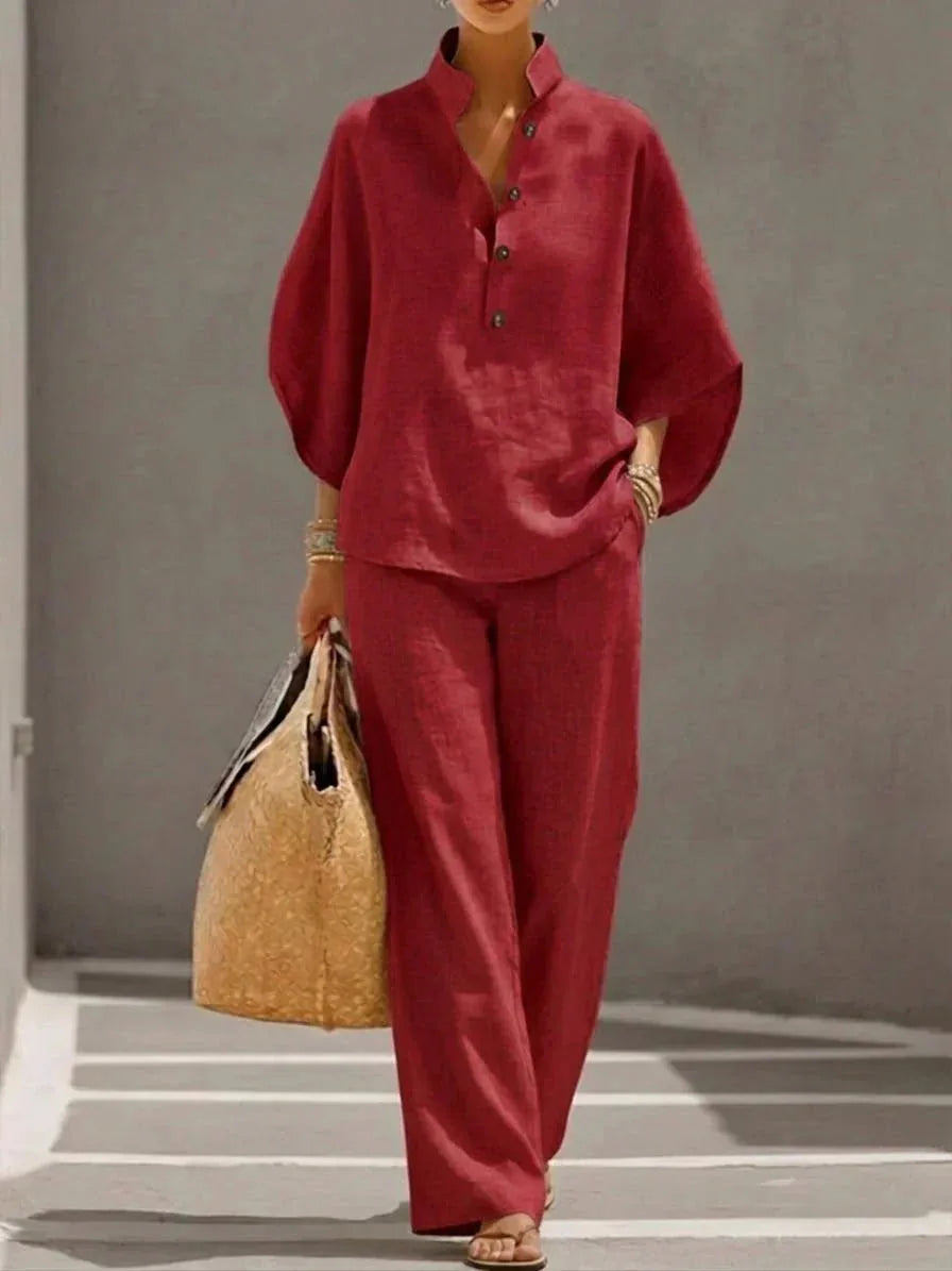 Red version of the set captured walking, highlighting the loose batwing sleeve silhouette and wide-leg pant drape.