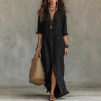 Front view of a black collared maxi shirt dress with button placket worn with layered beaded necklaces