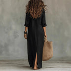 Back view of the black maxi shirt dress showing its relaxed silhouette and side hem slit
