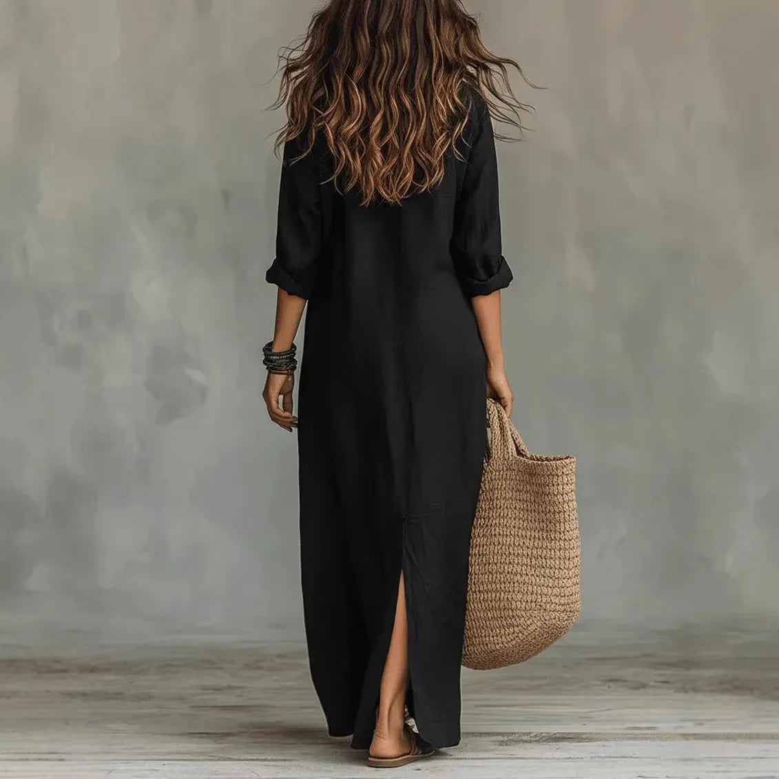 Back view of the black maxi shirt dress showing its relaxed silhouette and side hem slit