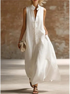 White sleeveless maxi dress with mandarin collar and frog fastenings, flowing ankle-length silhouette