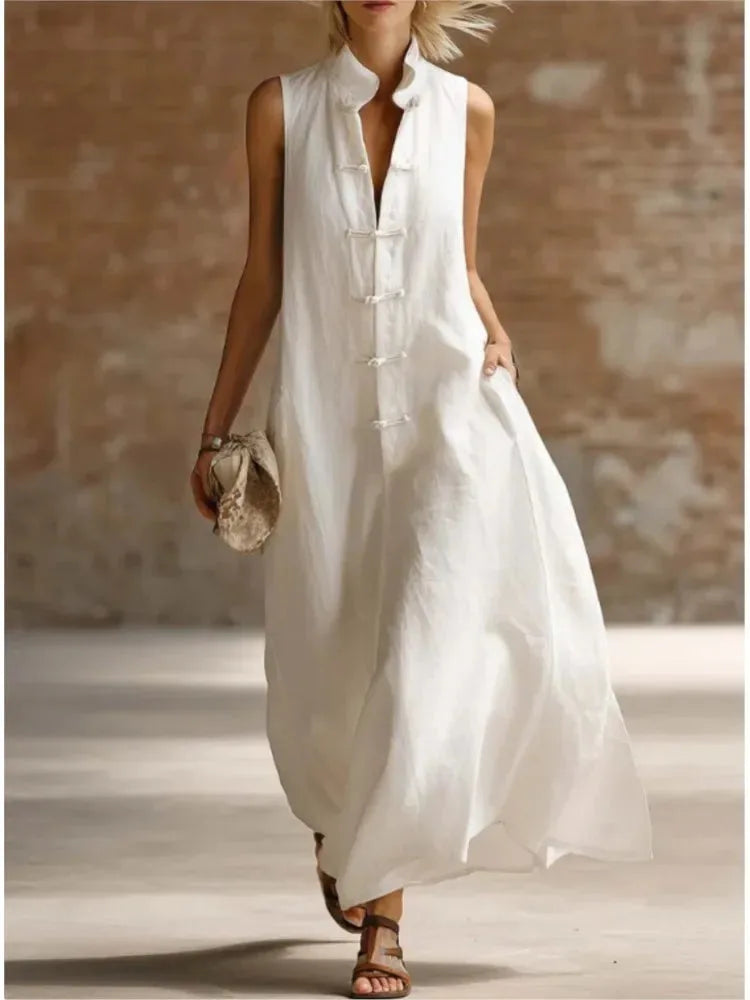 White sleeveless maxi dress with mandarin collar and frog fastenings, flowing ankle-length silhouette