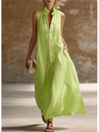 Green linen maxi dress with frog button front and stand collar, worn with a woven clutch