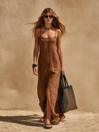 Close front view of a brown linen maxi dress with scoop neckline, thin straps and visible side split detail