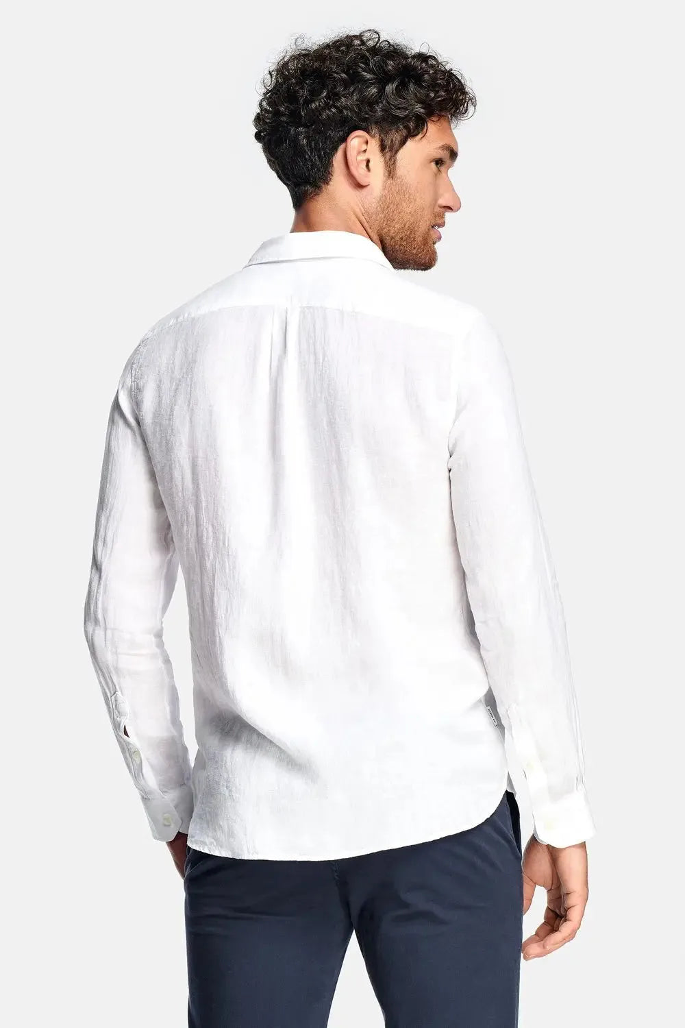 Back view of white linen shirt showing relaxed fit across the shoulders and back yoke