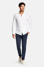 Full-length front view of model wearing the white linen shirt with navy chinos and cream slip-on sneakers