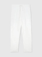 Flat lay of white linen trousers with drawstring waist, tapered hem and pleated front