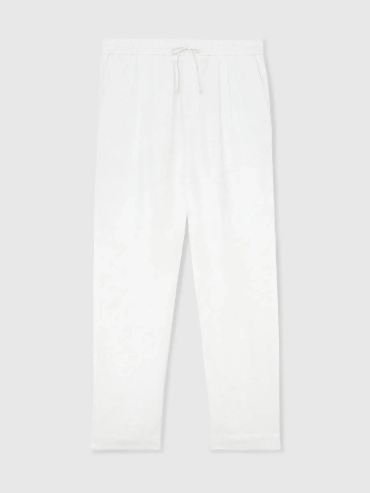 Flat lay of white linen trousers with drawstring waist, tapered hem and pleated front