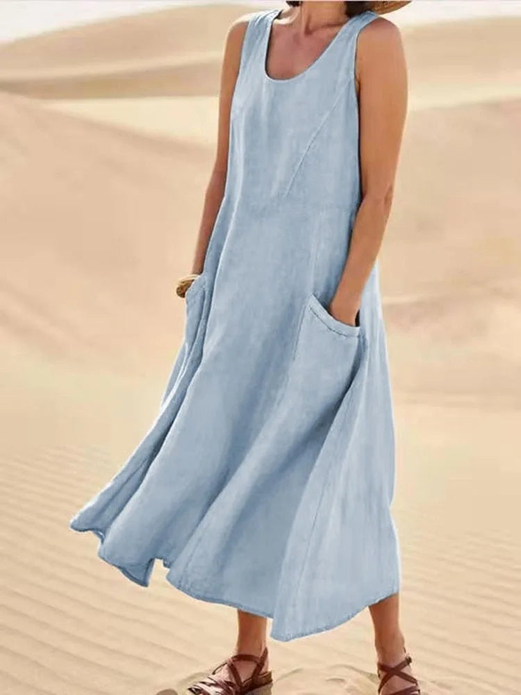 Light blue linen sleeveless midi dress with front pocket detail, full length outdoor shot