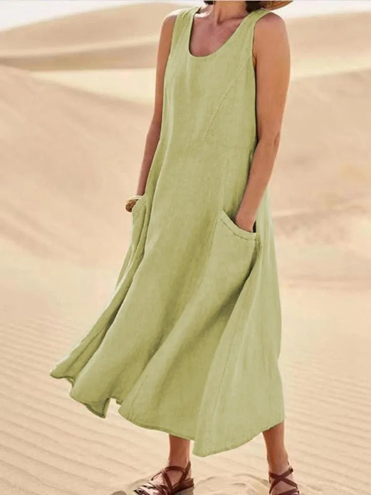 Light olive green linen sleeveless midi dress with A-line skirt, worn with sandals in sand