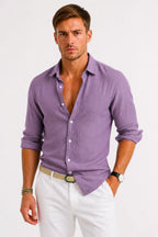 Man in a soft purple linen shirt with button-up front, pointed collar and relaxed fit, styled with white trousers.