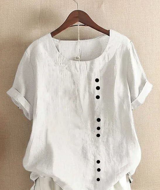 White linen blouse close-up, highlighting the relaxed fit, rolled cuffs and button detail down the front