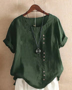 Dark green linen blouse with round neckline, worn over a white skirt, showing the overall loose fit
