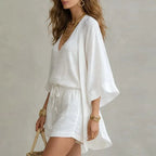 Side profile showing the flowing drape of the white linen kimono layered over the matching top and shorts