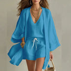 Woman modelling the three piece linen set in a bright blue colourway with kimono, V-neck top and shorts