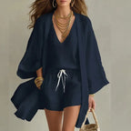 Three piece linen set shown in navy blue, styled with gold jewellery and a woven tote bag