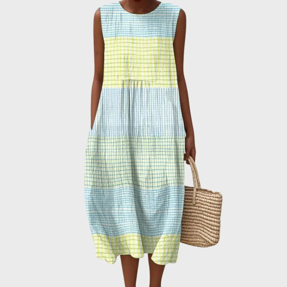 Sleeveless midi dress in blue and pale yellow checked linen, tiered loose fit, styled with a woven straw tote bag