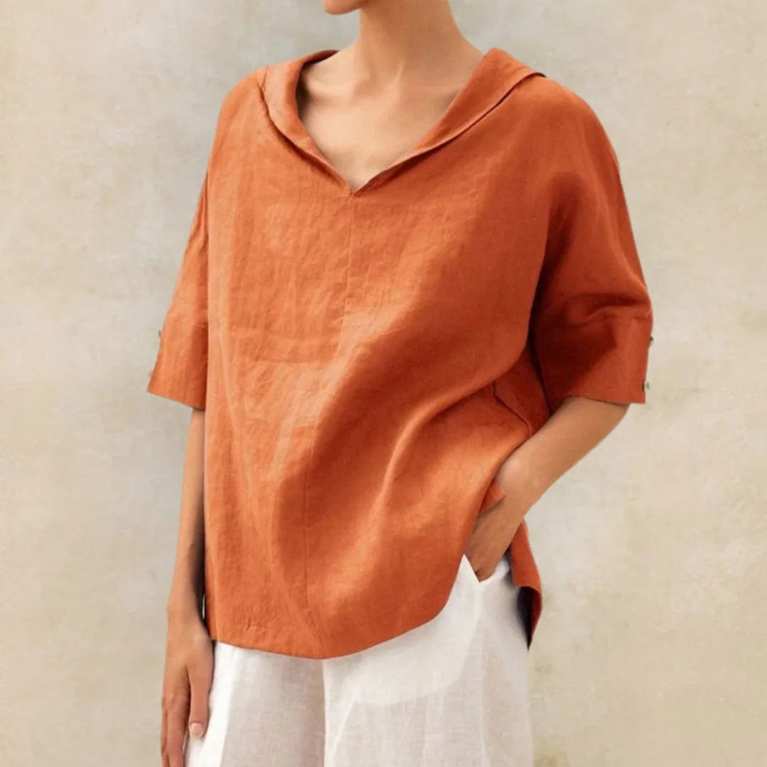 Orange linen collared V-neck blouse with rolled half sleeves and button cuff detail, close front view