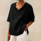 Black linen V-neck blouse with relaxed collar and rolled sleeves, shown against a plain backdrop