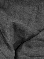 Close-up of the dark grey cotton-linen fabric texture, showing the natural woven weave and relaxed, slightly crinkled finish